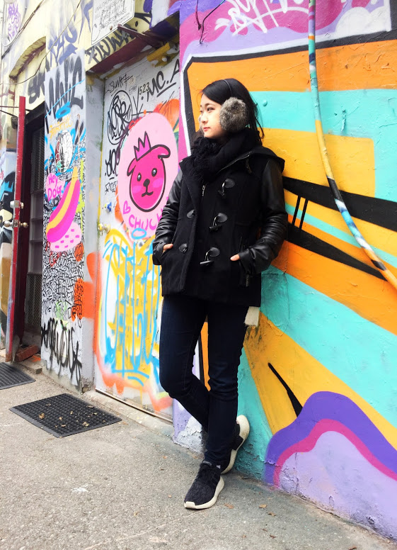 Marie standing against a wall with graffiti